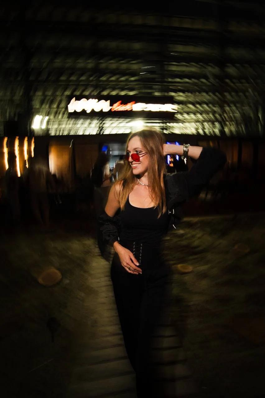 A girl in a dark outfit smiling during a beach party at LEVEL Beach Batumi