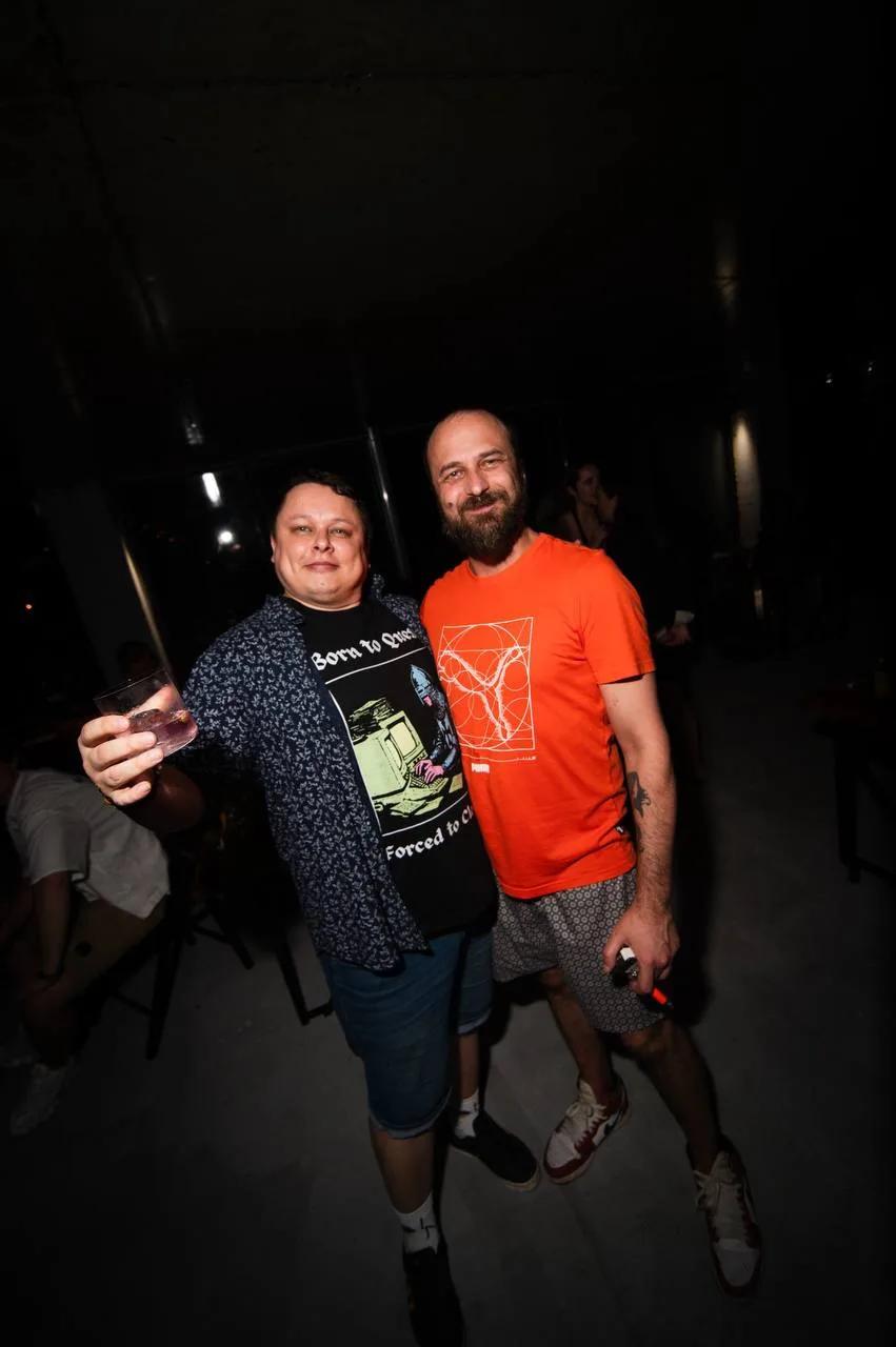Two smiling men relaxing with drinks at LEVEL Batumi bar