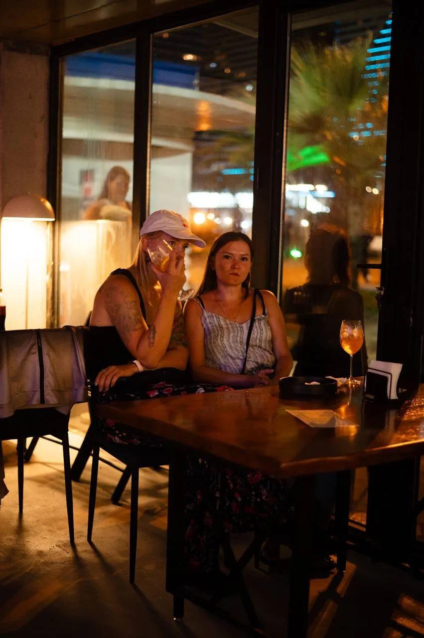 Two girls relaxing at a table with cocktails at LEVEL Beach Batumi in the evening