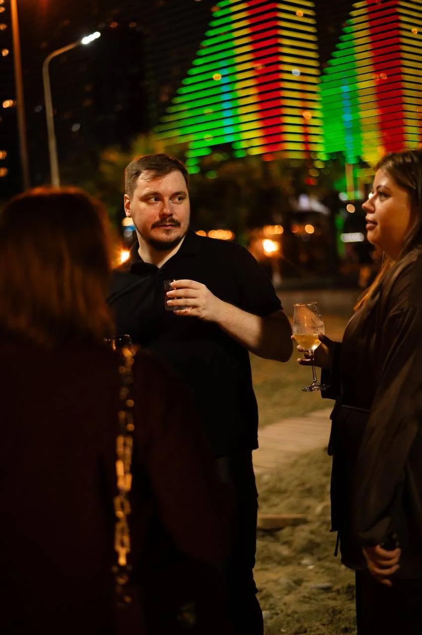 Guests with drinks chatting in the evening at LEVEL Beach Batumi on the New Boulevard