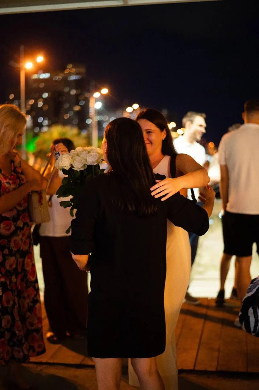 Guests hugging at a seaside party in LEVEL Beach Batumi under night lights