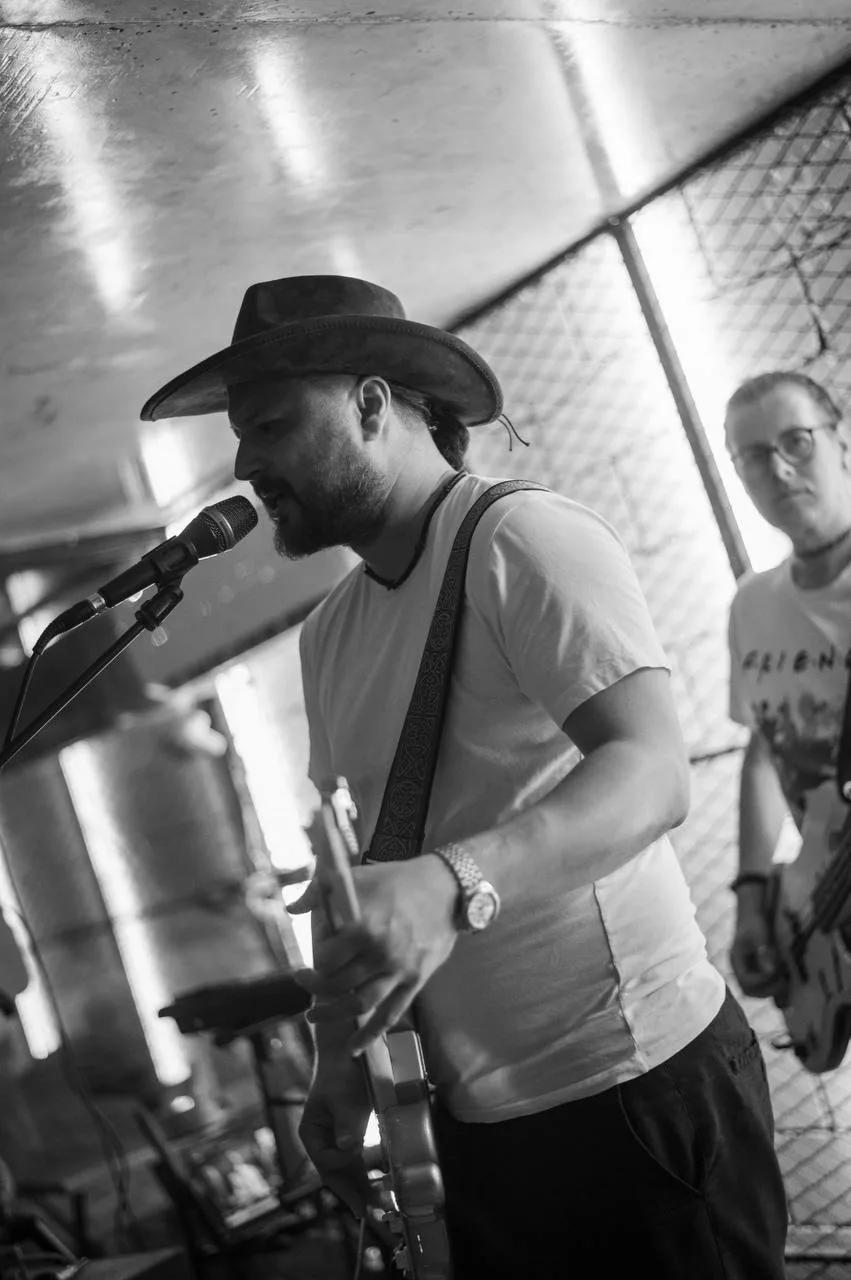 Musician in a hat sings into a microphone at LEVEL Beach Batumi